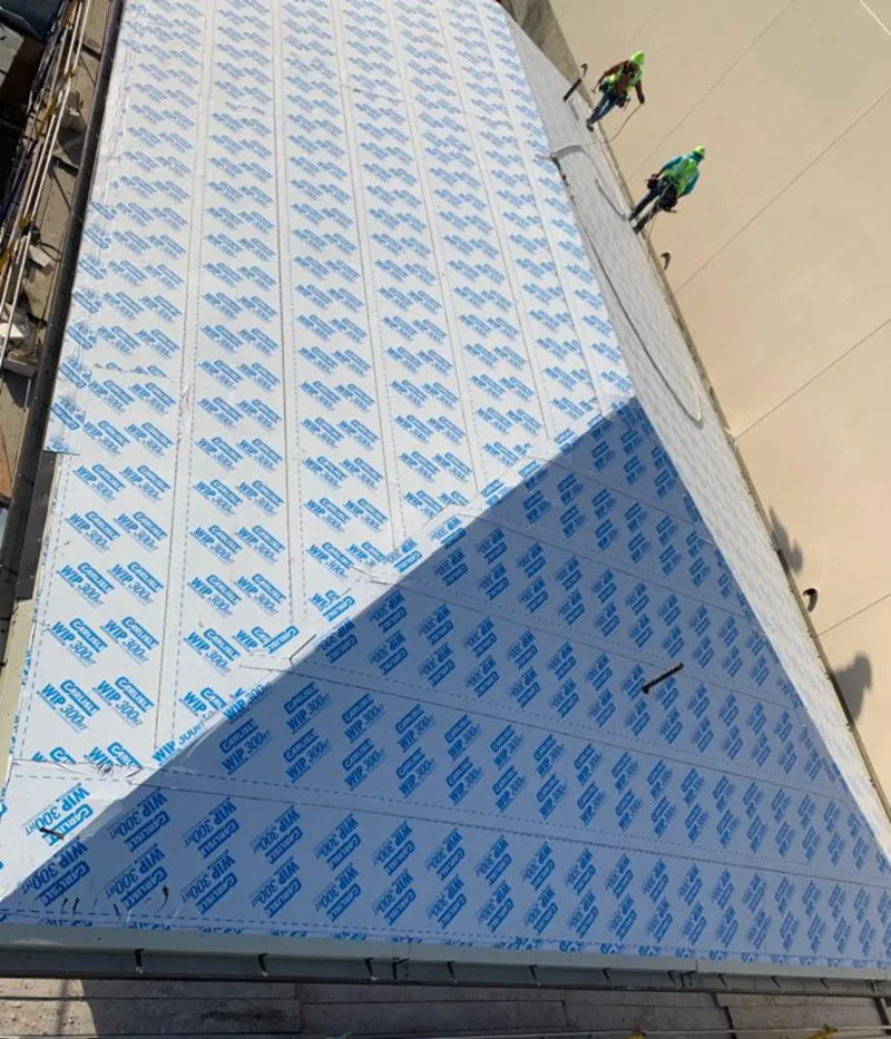 Professional roofers installing underlayment on a metal roof in Fairview